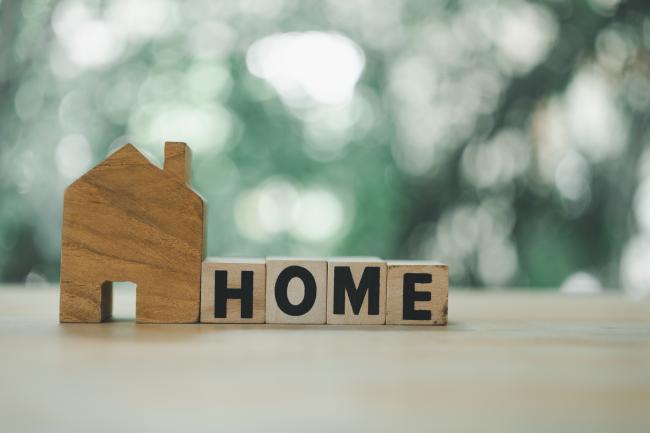 Small wooden home cut-out with blocks that read 'home'